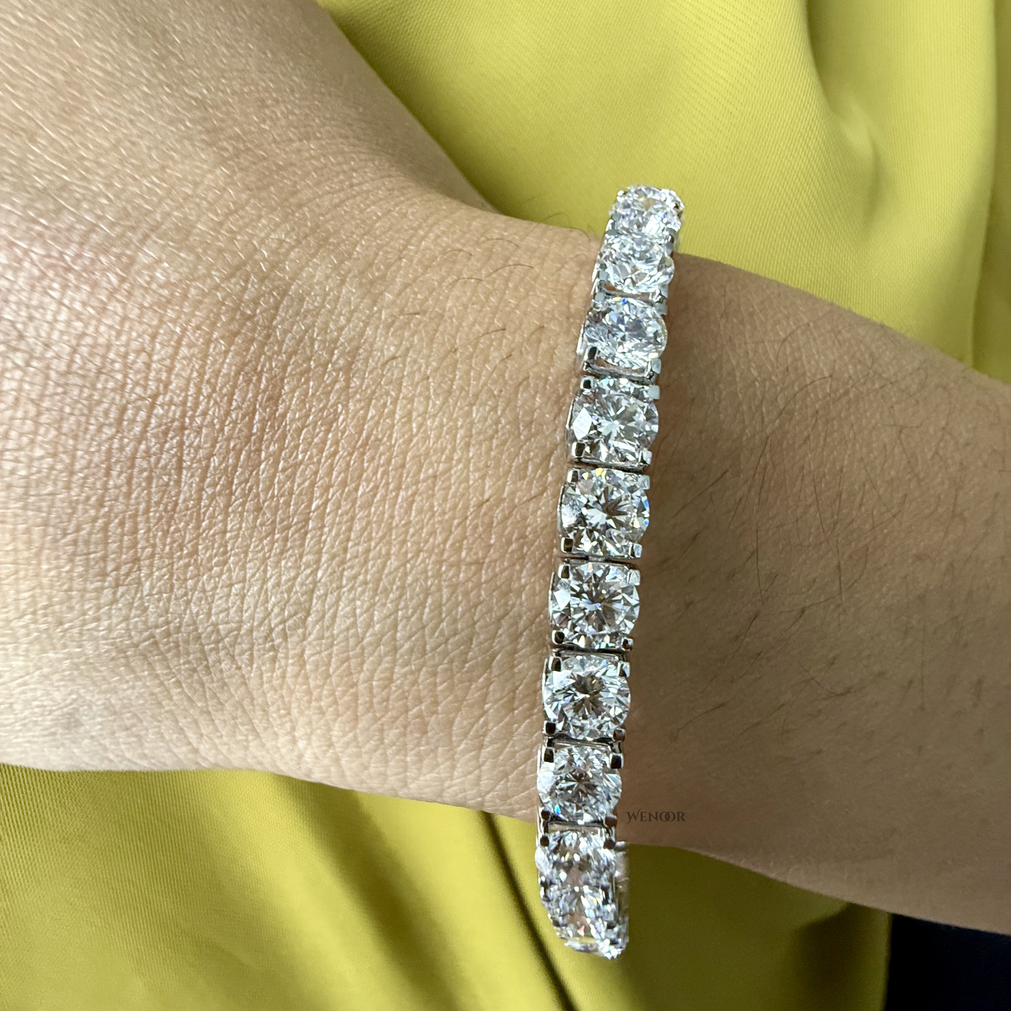 Lab grown diamond tennis bracelet with round stones in 14K gold four prong settings.