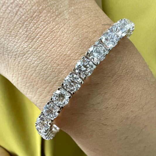 Lab grown diamond tennis bracelet with round stones in 14K gold four prong settings.