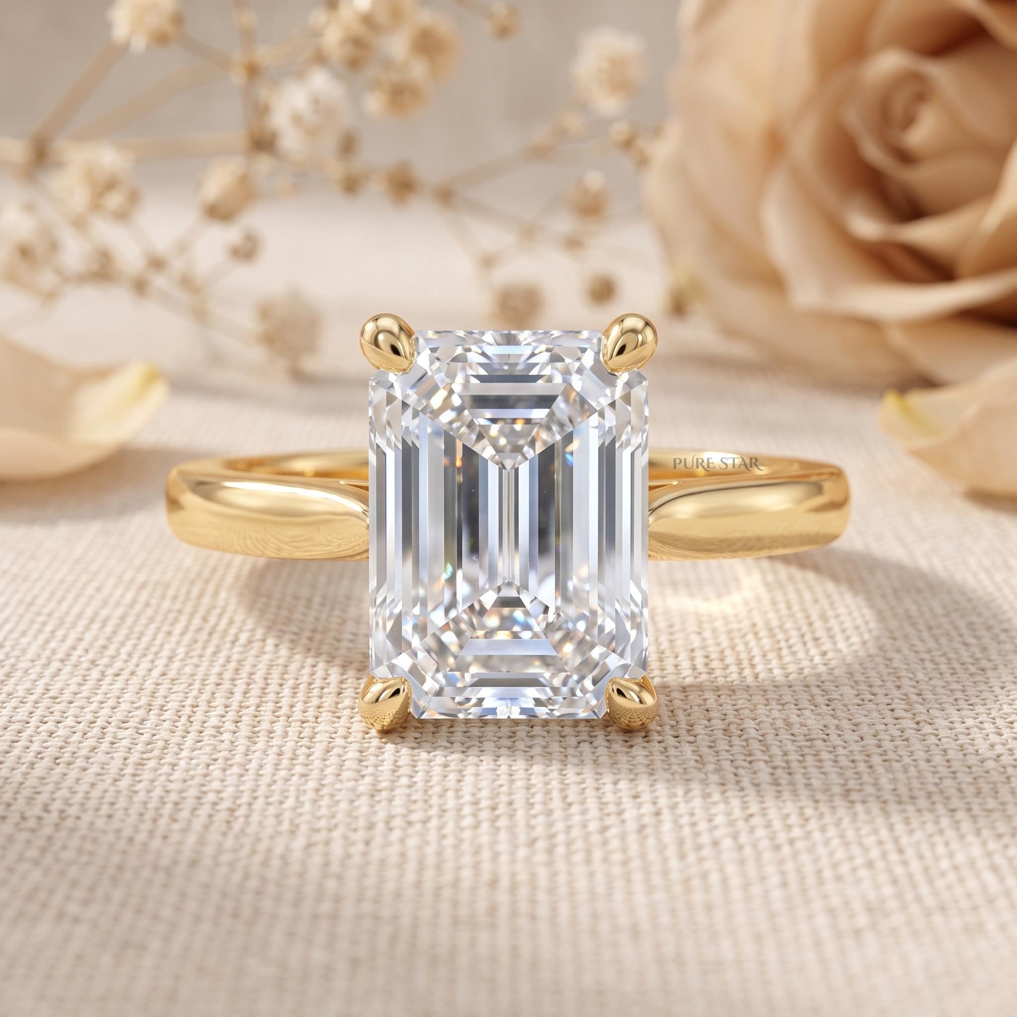 Emerald cut lab grown diamond engagement ring in 14K yellow gold solitaire setting on a white background.
