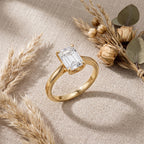 Luxury emerald cut engagement ring with hidden halo in solid gold displayed in a proposal ring box.