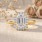 Emerald cut IGI certified lab grown diamond halo engagement ring in 14K yellow gold with round pavé band.